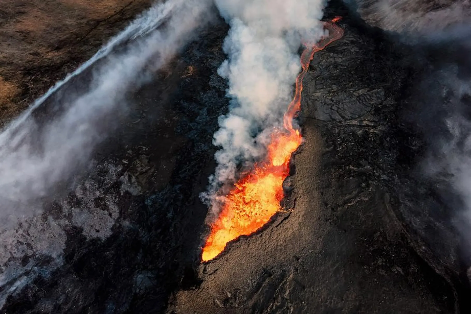 Aerial drone view of a lava flow and steam venting from an active volcano in Iceland